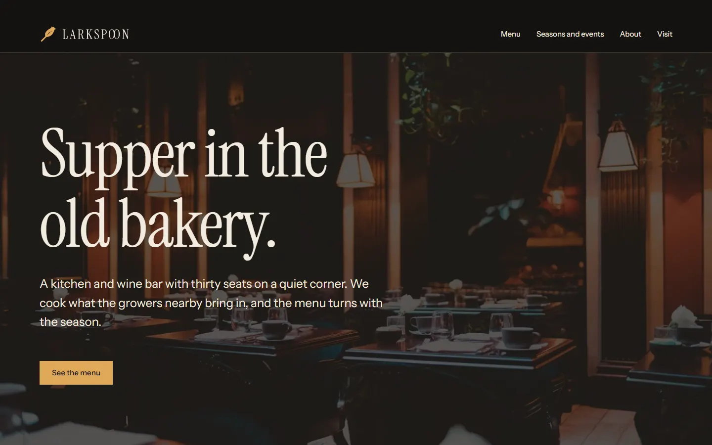 Start page of Larkspoon on a dark background: Supper in the old bakery, over a photo of the dining room at night